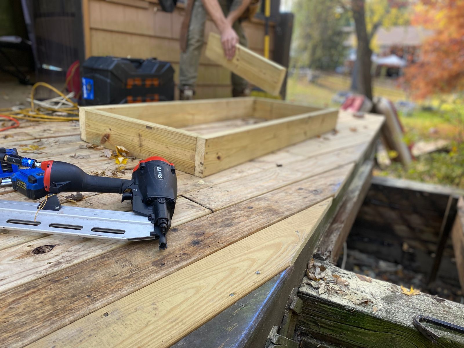 Framing a backyard deck: fresh lumber and a nail gun on new decking